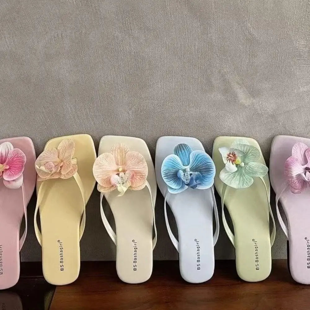 Set of flip-flops with floral decorations on a gray background