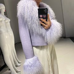 Person wearing a light purple outfit with white feathered sleeves taking a mirror selfie.