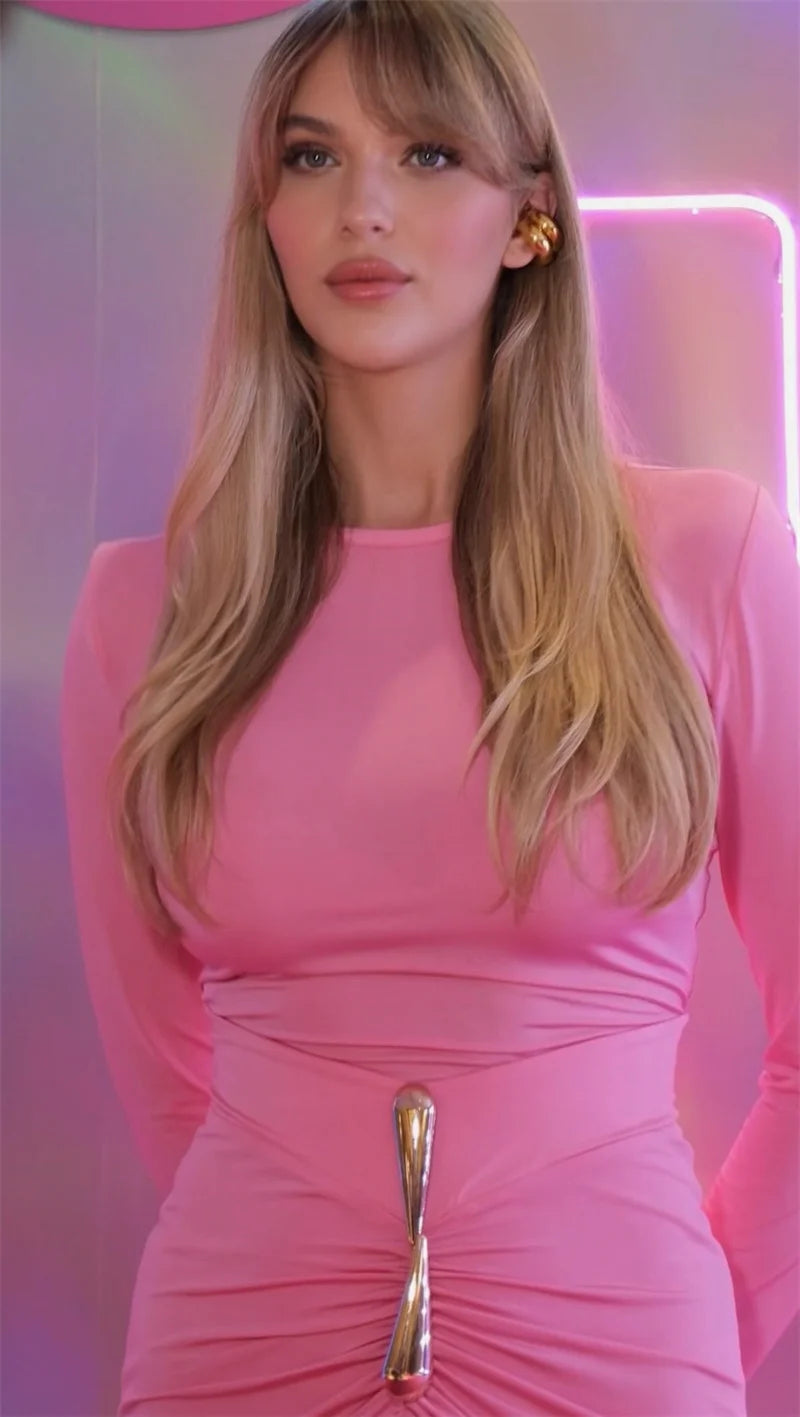 Woman wearing a pink dress with a gold clasp against a pink neon light background