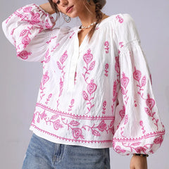 Close-up of the V-neck and embroidery on a white cotton blouse