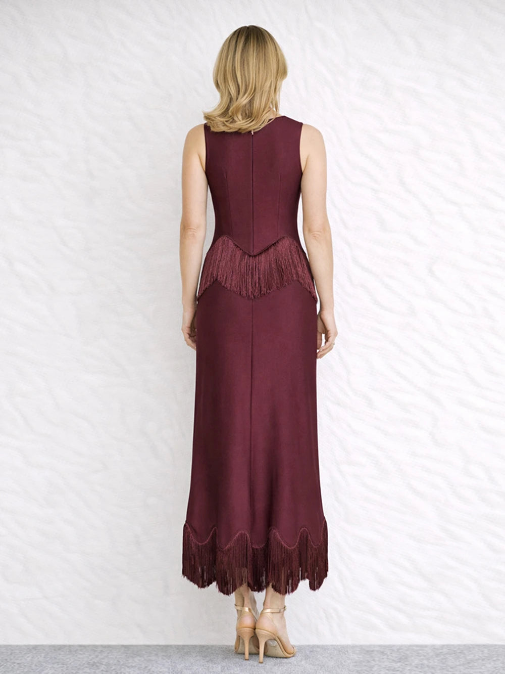 Back view of a burgundy sleeveless O-neck maxi dress with fringe trim.