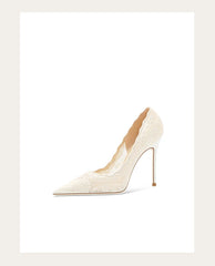White high-heeled shoe on a light beige background