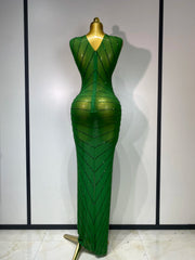 Green evening gown on a mannequin against a plain background