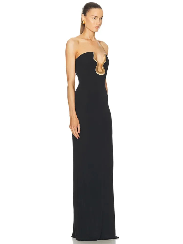 Side view of a strapless black maxi dress with a gold neckline accent.