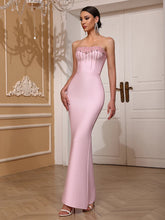 Woman wearing a pink strapless gown in an elegant interior setting