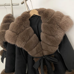 Black coat with brown fur collar on a hanger