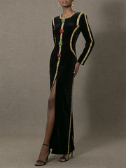 Black evening gown with gold trim and gemstones on a gray background