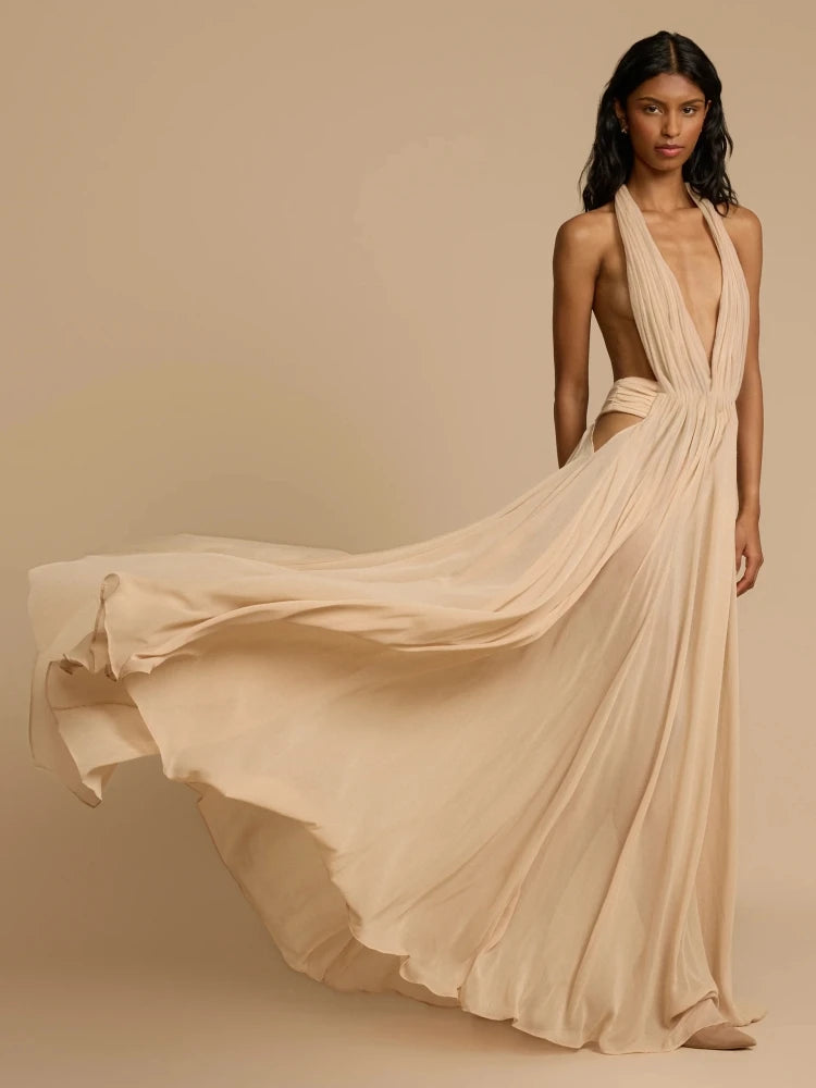 Woman wearing a flowing beige dress against a beige background