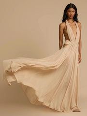 Woman wearing a flowing beige dress against a beige background