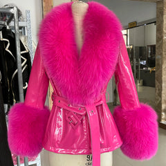 Pink glossy coat with fur trim on a mannequin in an indoor setting.