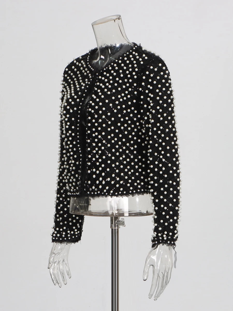 Black jacket with white polka dots on a mannequin against a white background