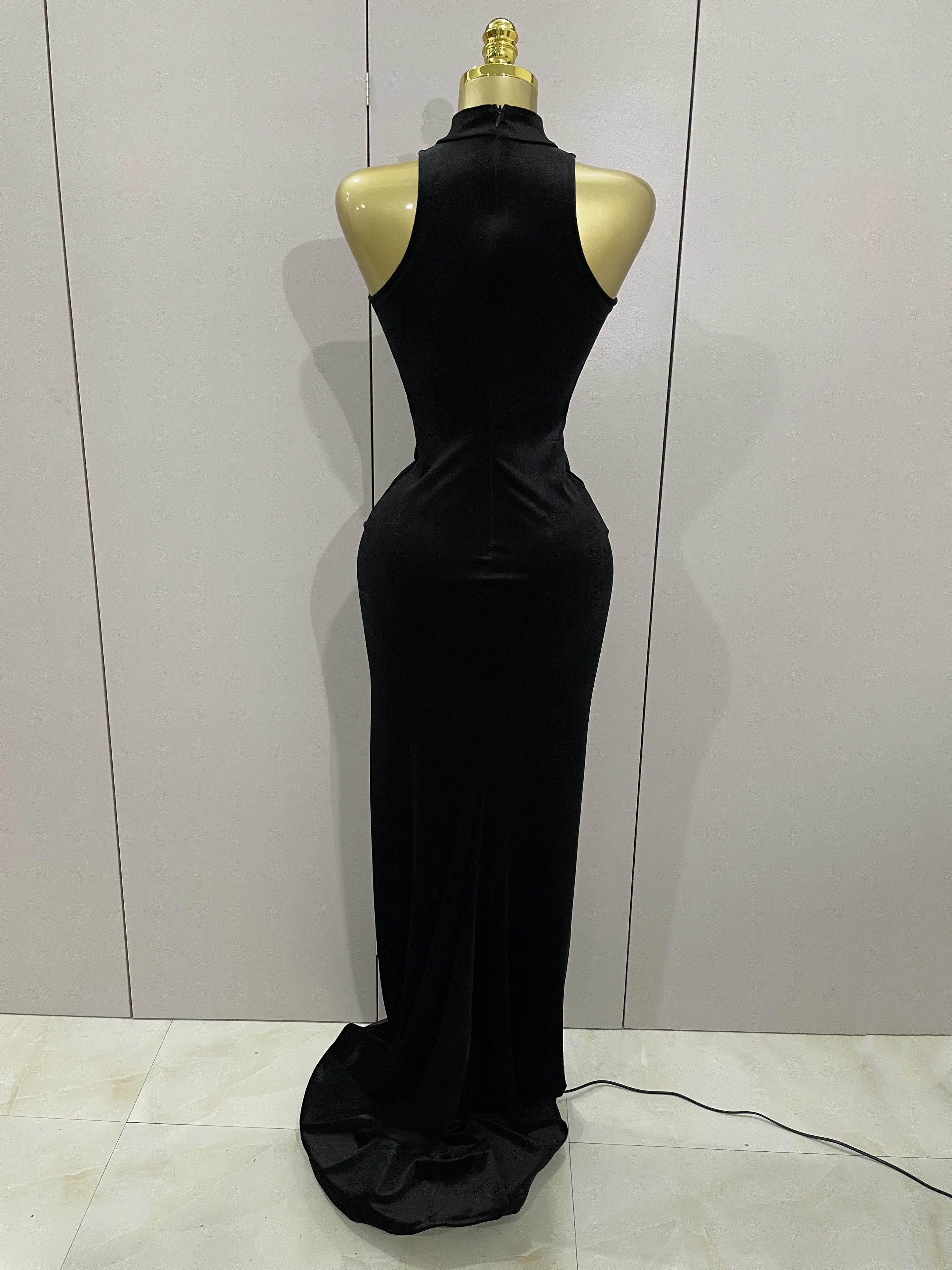 Black evening gown on a mannequin against a plain background
