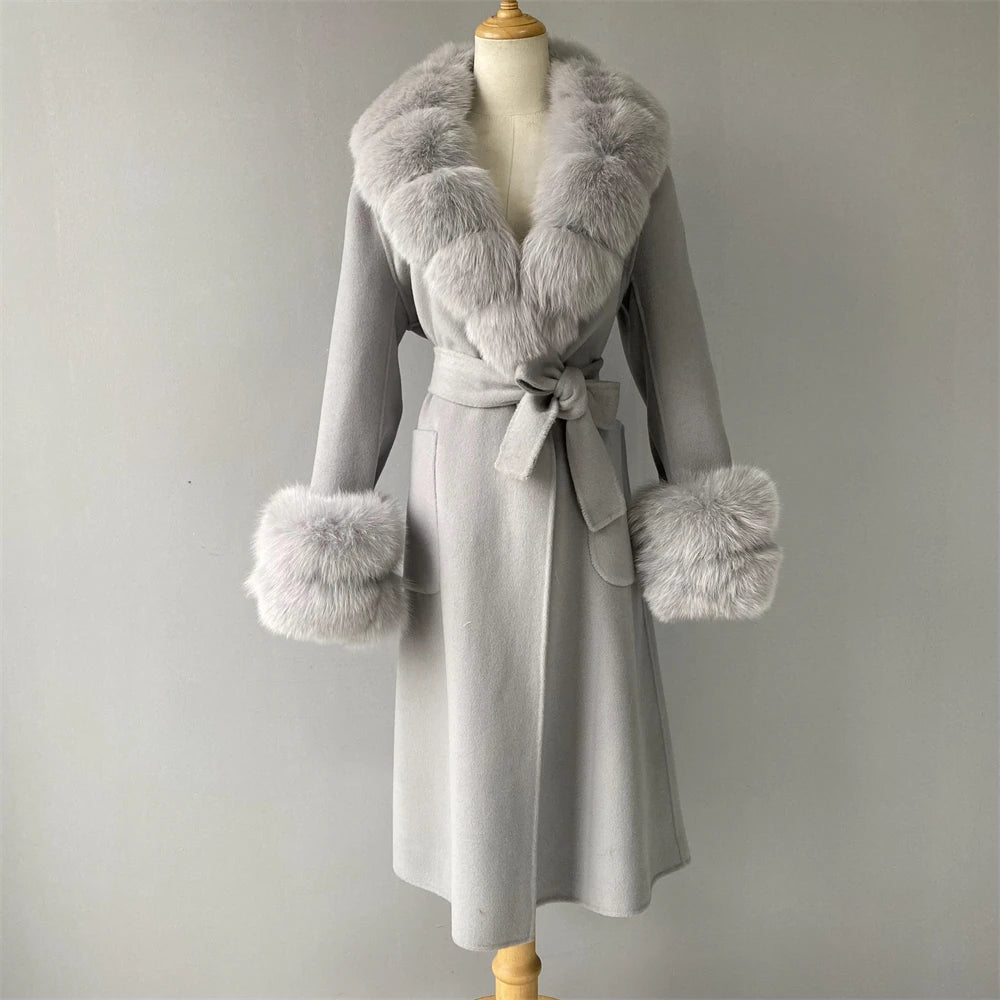 Gray coat with fur accents on a mannequin against a plain background