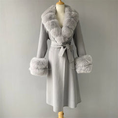 Gray coat with fur accents on a mannequin against a plain background