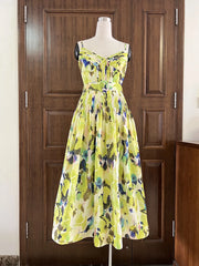 Yellow floral dress on a mannequin against a wooden door.
