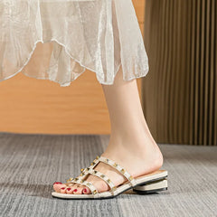 Model wearing blue studded block heel slide sandals
