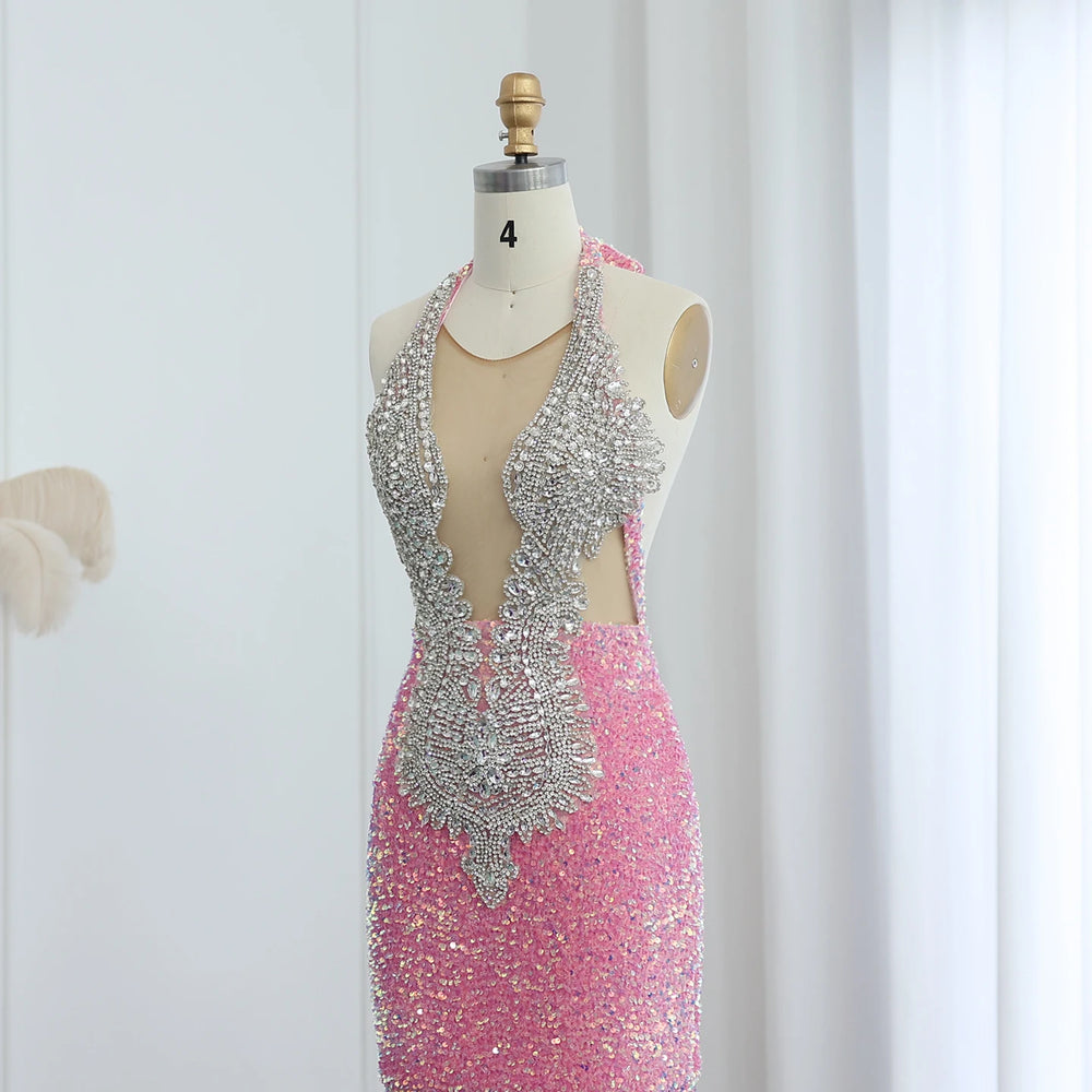 Mannequin wearing a pink dress with silver embellishments against a white curtain background