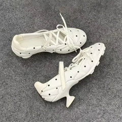 Detail shot of the sculptural heel on a white polka dot Mary Jane shoe.