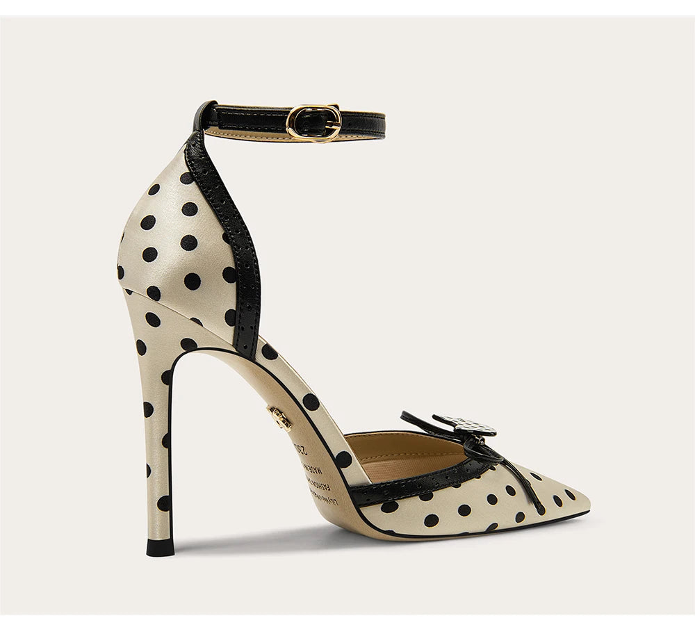 Polka dot high-heeled shoe with black accents on a light gray background