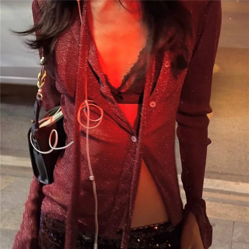 Person wearing a red glittery cardigan with a blurred background