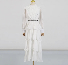 White dress with lace details on a mannequin against a plain background