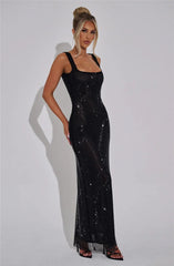 Woman wearing a black sequin dress against a plain background