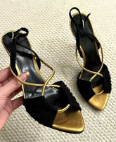 Black and gold stiletto heeled sandals with crisscross straps