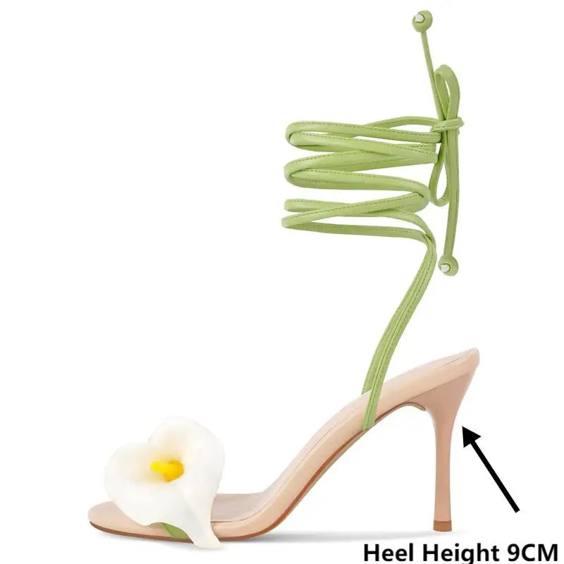 High-heeled sandal with green laces and a calla lily design on a white background