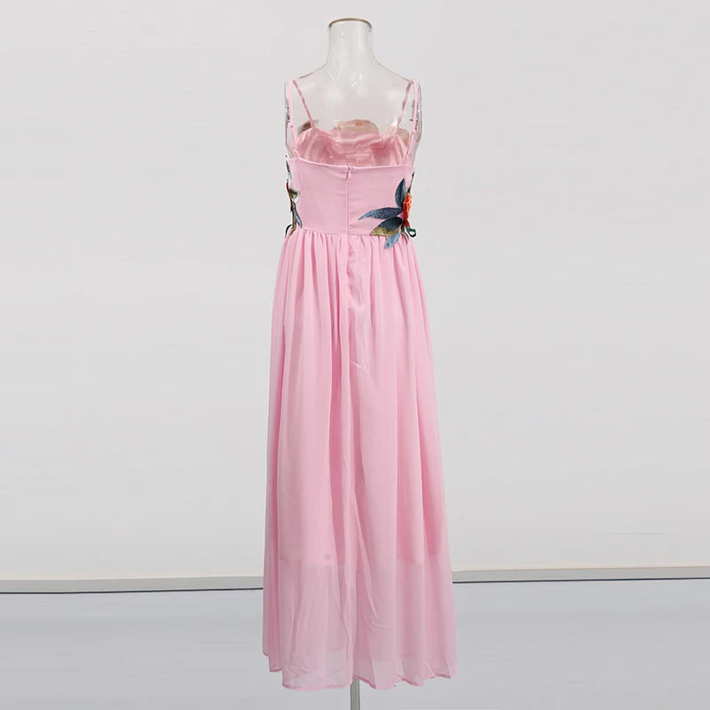 Pink dress with floral embroidery on a mannequin against a white background