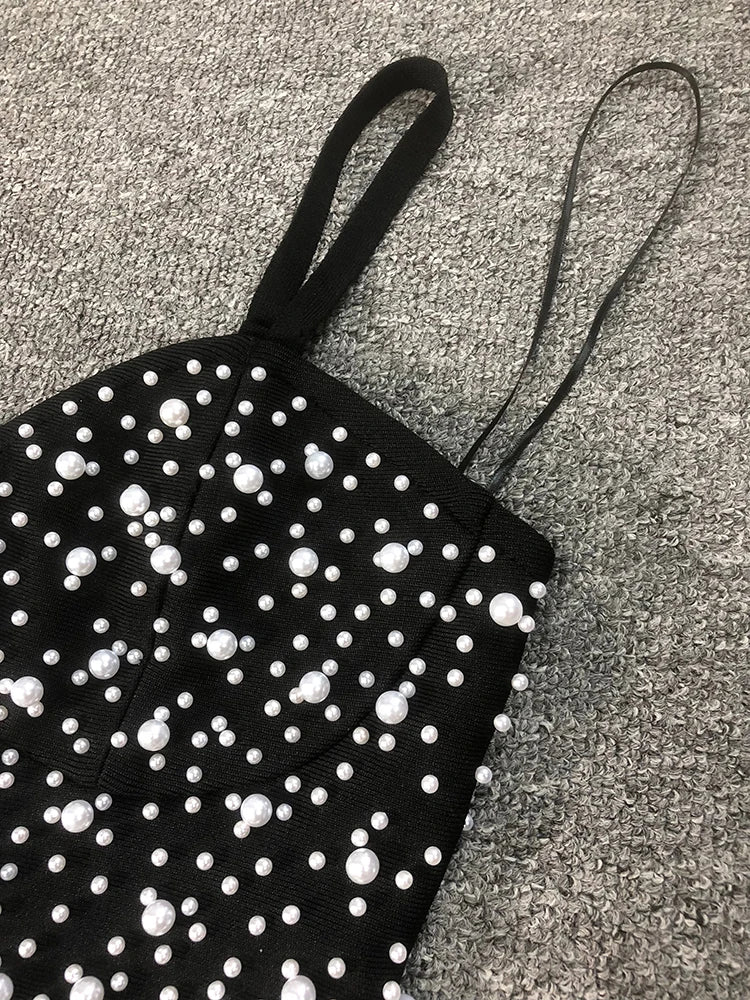 Black top with white polka dots on a textured surface