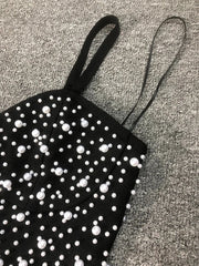 Black top with white polka dots on a textured surface