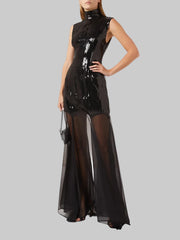 Black dress with sheer overlay worn by a model on a white background