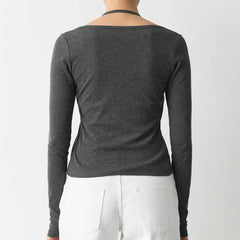 Person wearing a dark gray long-sleeve top on a white background