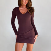 Woman wearing a brown ribbed dress against a plain background