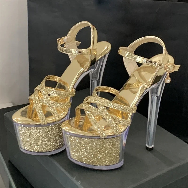 Gold glitter high-heeled shoes on a black surface with a dark background