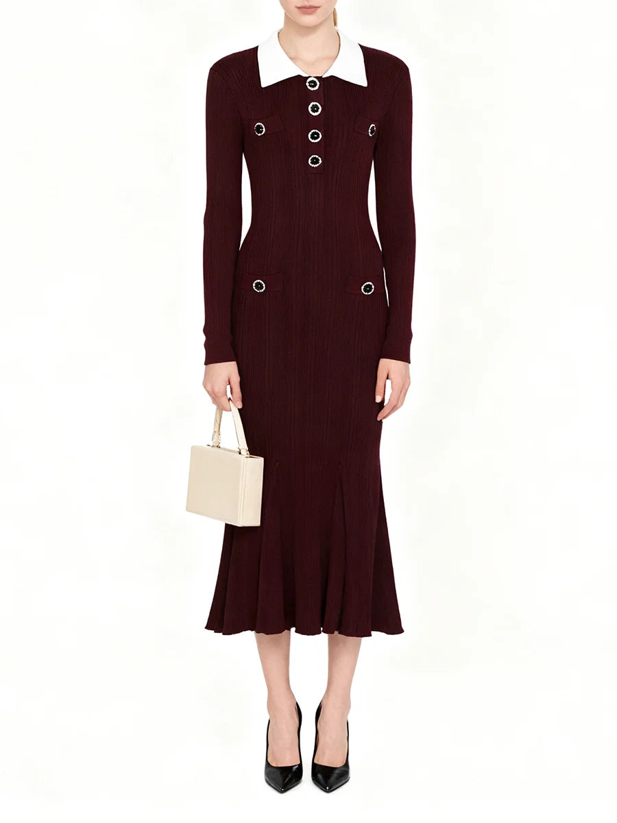 Woman wearing a burgundy dress with white collar and buttons on a white background