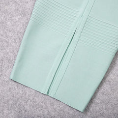 Light green fabric with pleated details on a gray surface