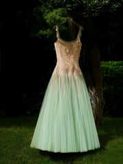 Sequined dress with a gradient from gold to green hanging against a dark background.