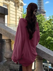 Person in a pink dress standing on a balcony with the Eiffel Tower in the background