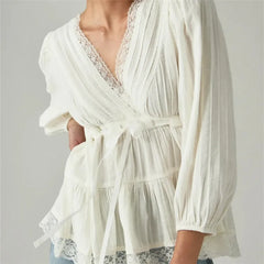 Close-up of white lace detail on v-neck wrap peplum top
