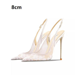 White high-heeled shoes with gold accents on a white background