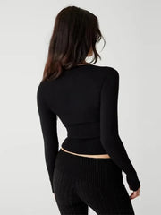 Person wearing a black long-sleeve top and pants on a white background