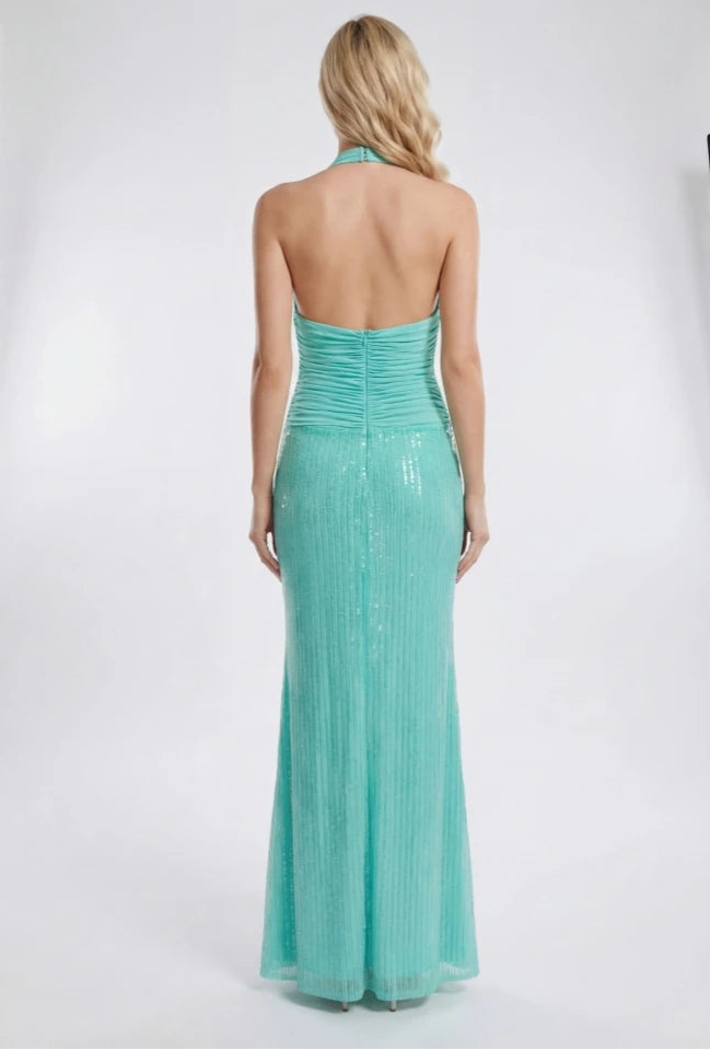 Woman wearing a turquoise evening gown in a photo studio setting
