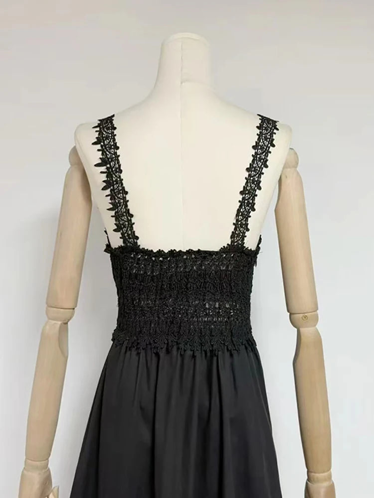 Black dress with lace detailing on a mannequin against a white background