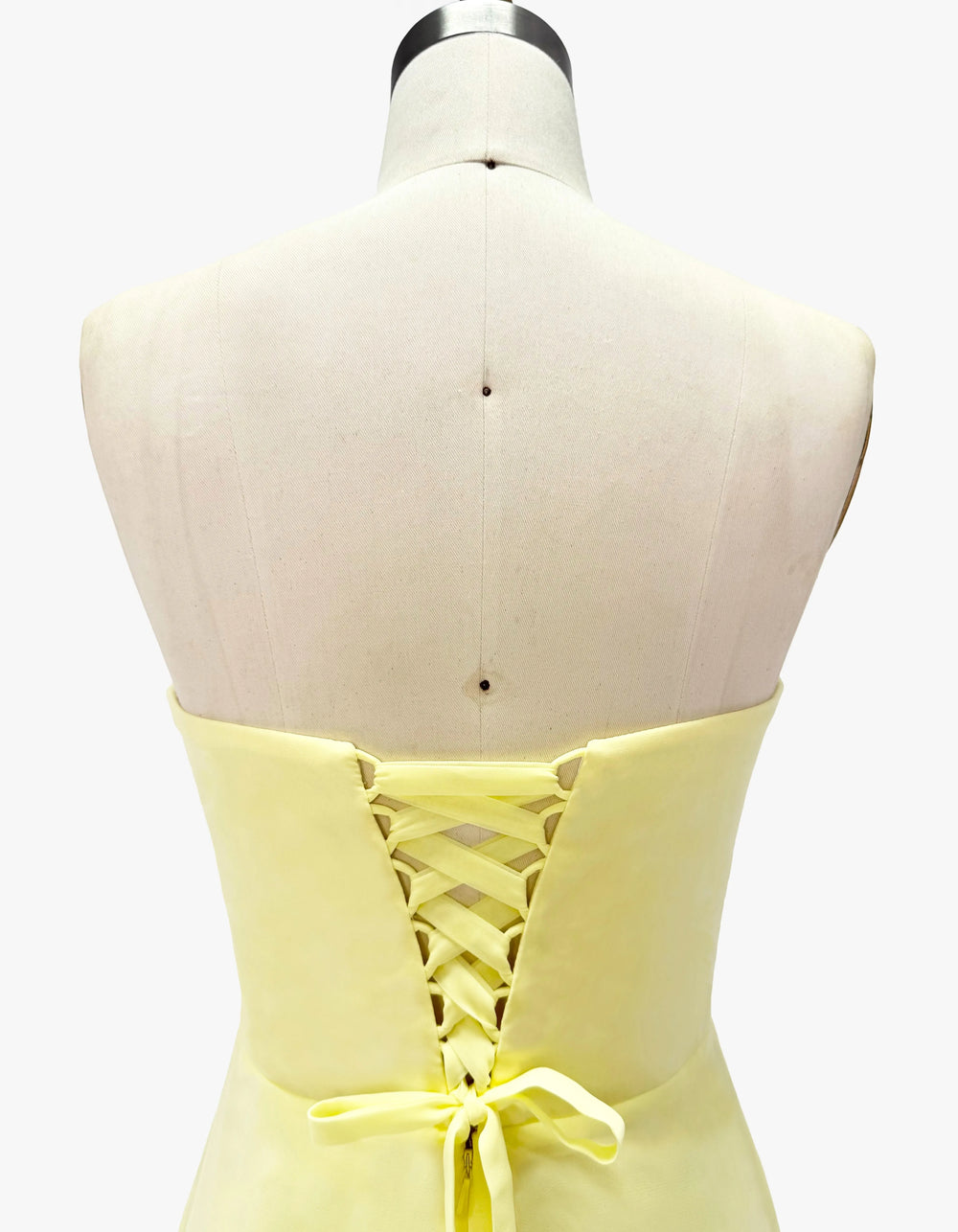 Yellow dress on a mannequin with a white background