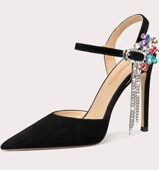 Black high-heeled shoe with colorful embellishments on a light gray background