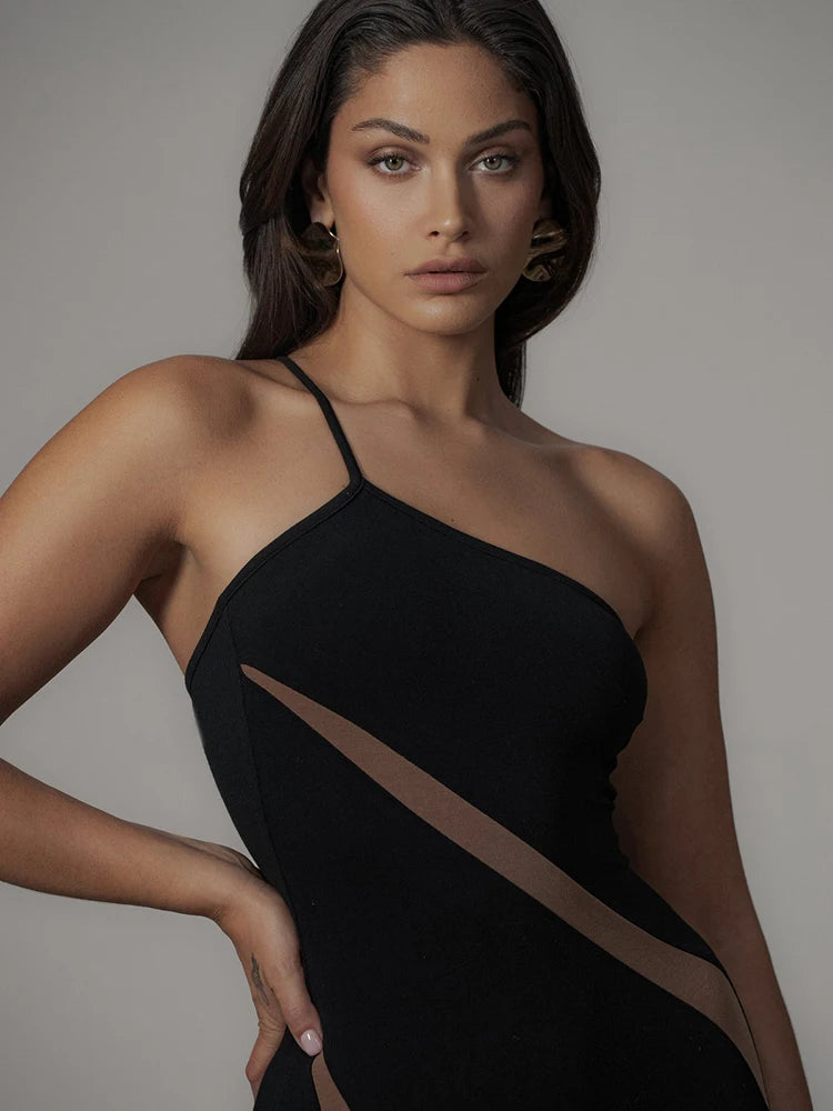 Woman wearing a black halter neck dress against a neutral background