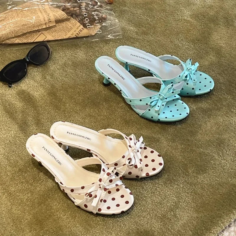 Pair of white with red polka dot bow kitten heel mules and light blue with black polka dot bow kitten heel mules