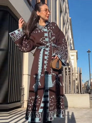 Woman wearing a patterned dress standing outdoors with a building in the background