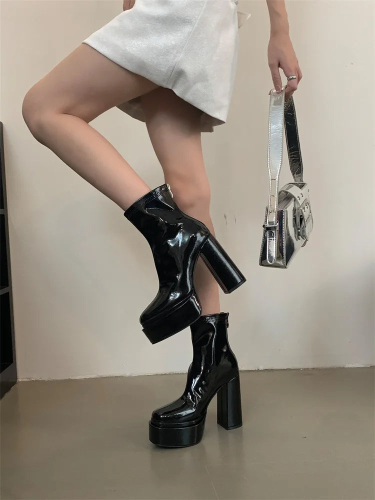 Person wearing black platform boots with a plain background